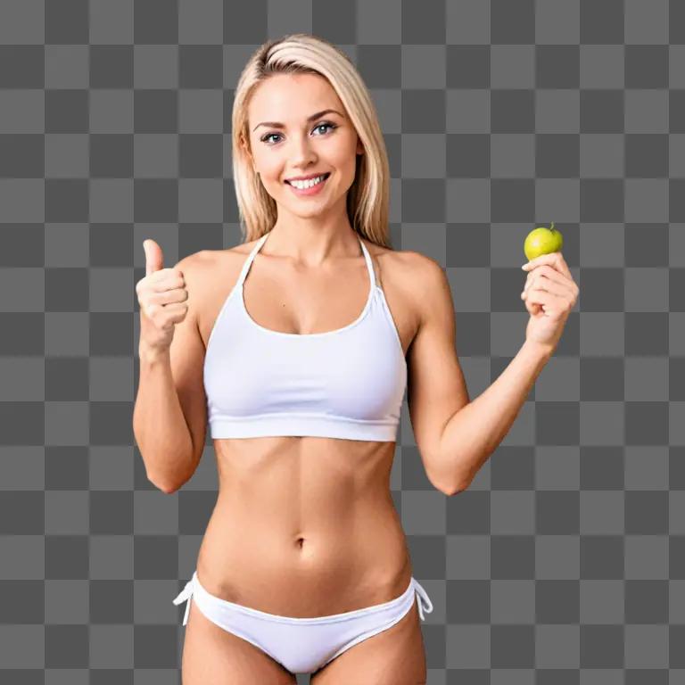 A smiling woman wearing a bikini top holds a green apple