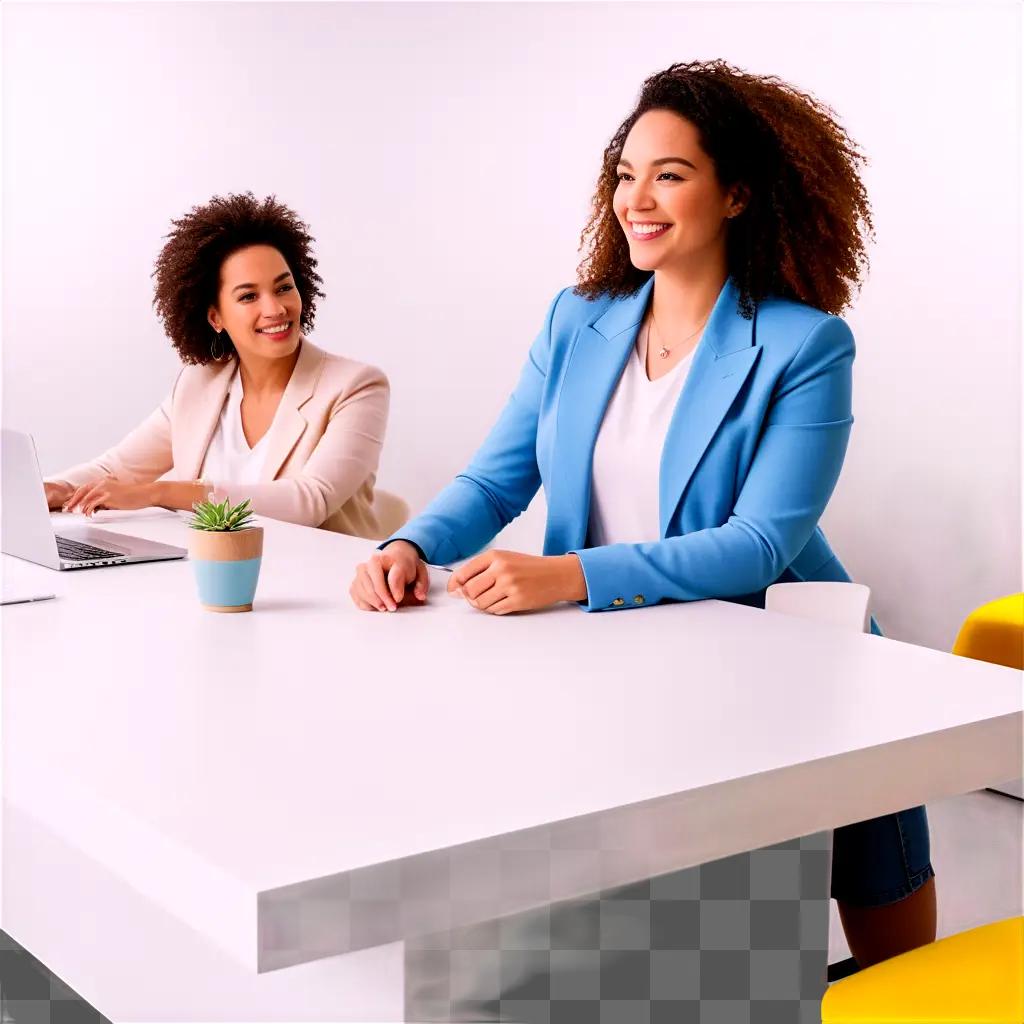 Two women sitting at a white table with laptops