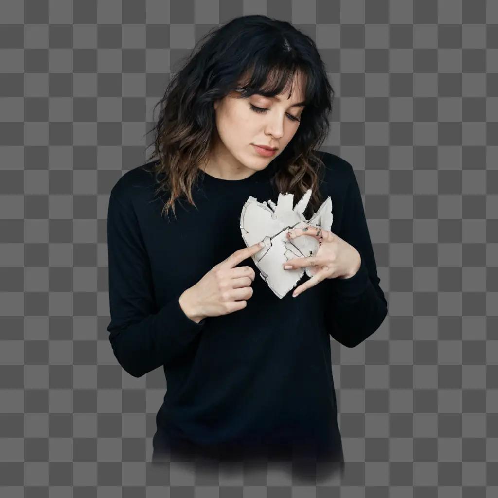 broken heart tattoo A woman wearing a black shirt looks at a piece of paper