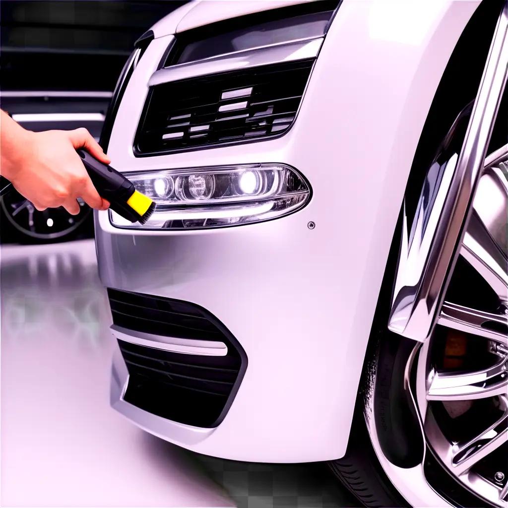 person holding a vacuum cleaner near a cars front light