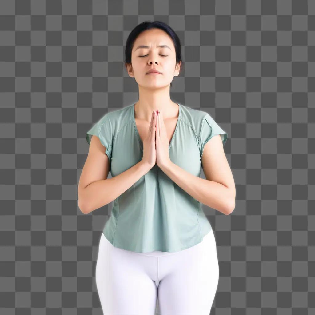 woman in white pants and a green shirt with her hands touching her chest